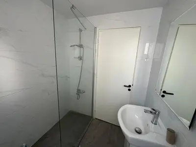 a white bathroom with a shower and a sink at 1 bedroom flat 200m from beach in Limassol