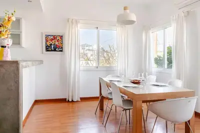a dining room with a table and white chairs at Central Escape in Limassol