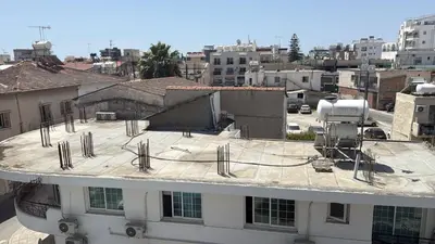 a view of a building with scaffolding on the roof at Unique City Center Rooms, 150m from Chabad Lubavitch in Larnaka