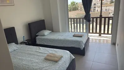 two beds in a room with a balcony at Unique City Center Rooms, 150m from Chabad Lubavitch in Larnaka