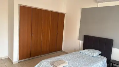 a bedroom with a bed and a wooden cabinet at Unique City Center Rooms, 150m from Chabad Lubavitch in Larnaka