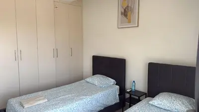 two beds in a room with white cabinets at Unique City Center Rooms, 150m from Chabad Lubavitch in Larnaka