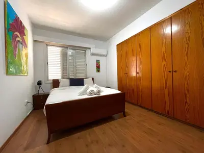 a bedroom with a large bed and wooden cabinets at Comfort Stay in Nicosia - Aglantzia RIK in Nicosia