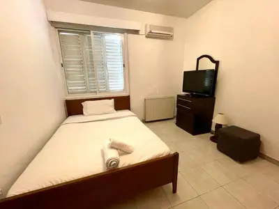a small bedroom with a bed and a television at Comfort Stay in Nicosia - Aglantzia RIK in Nicosia