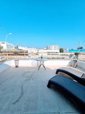 a patio with a table and a bench on a roof at Greco 356 Apartment in Protaras