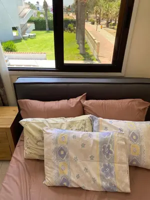 a bed with pillows in front of a window at A sea breeze villa in Pyla