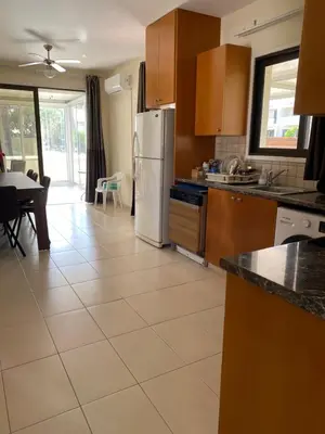 a kitchen with a white refrigerator and a table at A sea breeze villa in Pyla
