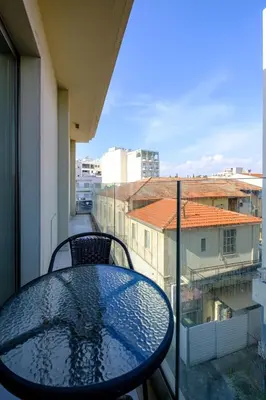 a table on a balcony with a view of a city at Downtown Comfort Apartment in Larnaka