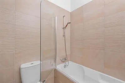 a bathroom with a shower and a toilet and a tub at Downtown Comfort Apartment in Larnaka