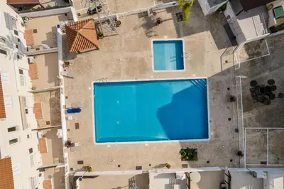 an overhead view of a swimming pool inbetween two buildings at Villa Poppy in Paralimni