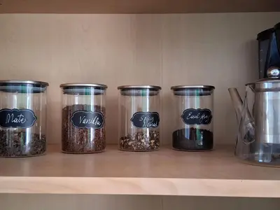 a shelf with four jars filled with spices at Villa Poppy in Paralimni