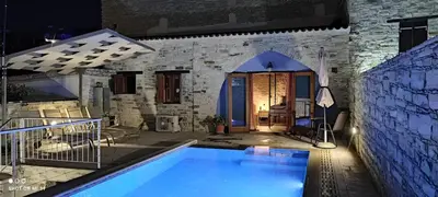 a villa with a swimming pool at night at Mountain View Oasis in Skarinou