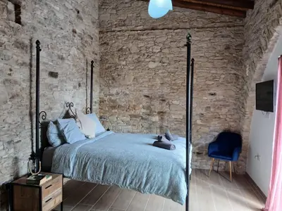 a bedroom with a bed and a stone wall at Mountain View Oasis in Skarinou