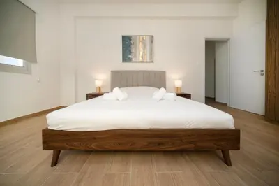 a bedroom with a large white bed with two lamps at Near City center 1 bedroom flat in Nicosia