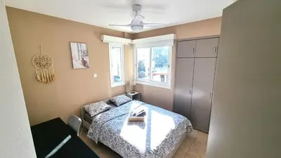 a bedroom with a bed and a couch and a window at 5 Min Walk to Beach, Perfect Seaside Escape in Larnaka