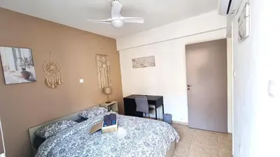 a bedroom with a bed and a ceiling fan at 5 Min Walk to Beach, Perfect Seaside Escape in Larnaka