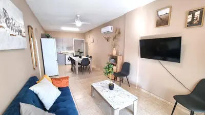 a living room with a blue couch and a table at 5 Min Walk to Beach, Perfect Seaside Escape in Larnaka