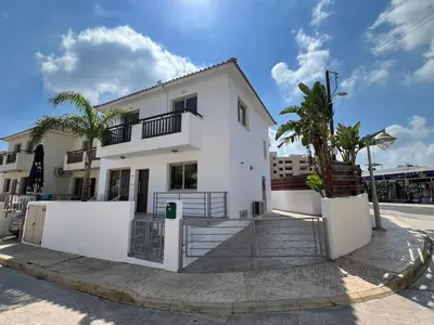 a white house with palm trees in front of it at Amour Et Citrons in Protaras