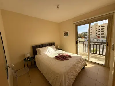 a bedroom with a bed and a large window at Amour Et Citrons in Protaras