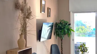 a living room with plants and a mirror on the wall at 5 Min Walk to Beach, Perfect Seaside Escape 3BR Shared Apartment in Larnaka
