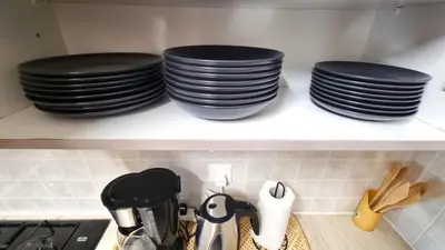 three stacks of plates on a shelf in a kitchen at 5 Min Walk to Beach, Perfect Seaside Escape 3BR Shared Apartment in Larnaka
