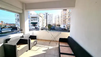 a balcony with chairs and a view of a city at 5 Min Walk to Beach, Perfect Seaside Escape 3BR Shared Apartment in Larnaka