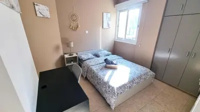 a small bedroom with a bed and a table at 5 Min Walk to Beach, Perfect Seaside Escape 3BR Shared Apartment in Larnaka