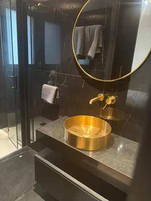 a bathroom with a gold sink and a mirror at Nicosia Delux in Nicosia