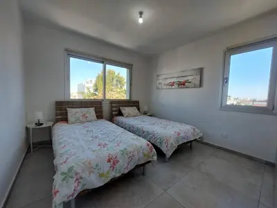 two beds in a room with two windows at Luxury 2 bedroom apartment 301 in Larnaka