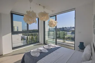 a bedroom with a bed and large windows at Protaras Almaria Villa ALM03 in Protaras