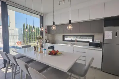a kitchen with a white table and chairs in a kitchen at Protaras Almaria Villa ALM03 in Protaras
