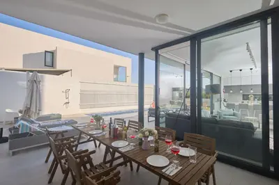 a dining table in a living room with a large window at Protaras Almaria Villa ALM03 in Protaras