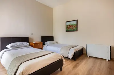 a bedroom with two beds and a picture on the wall at Central, renovated, fully equipped, spacious 3BD in Strovolos