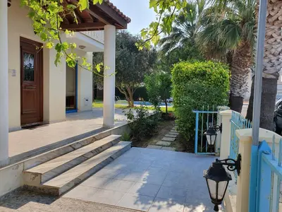 a porch of a house with a blue fence and stairs at De Angelo Villa in Pyla