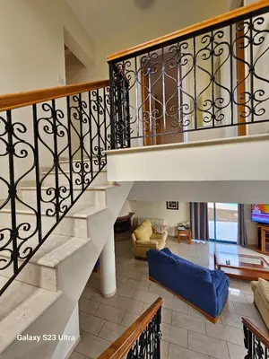 a staircase with a blue couch in a living room at De Angelo Villa in Pyla