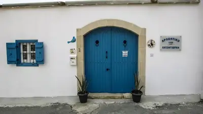 a blue door on the side of a white building at Sea View Penthouse in Larnaka