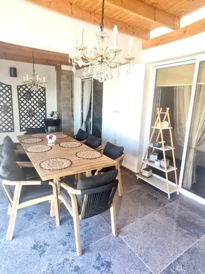 a dining room table with chairs and a chandelier at Sea View Penthouse in Larnaka