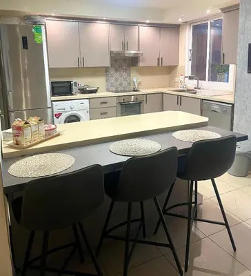 a kitchen with a table and four chairs at Sea View Penthouse in Larnaka