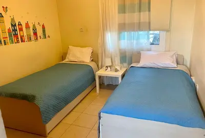 two twin beds in a room with a window at Sea View Penthouse in Larnaka