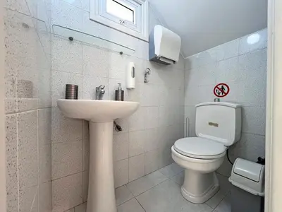 a white bathroom with a toilet and a sink at Albert's Apartment Center 101K in Larnaka