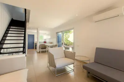 a living room with a couch and a stair case at Family Fig Tree Bay House in Protaras