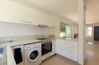 a white kitchen with a washing machine in it at Family Fig Tree Bay House in Protaras