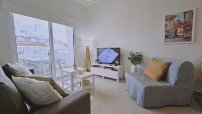 a living room with a couch and a tv and a table at STAY Amphora Apartment in Larnaka