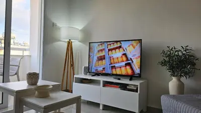 a living room with a flat screen tv on a white cabinet at STAY Amphora Apartment in Larnaka