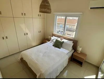 a small bedroom with a bed and a window at STAY Amphora Apartment in Larnaka
