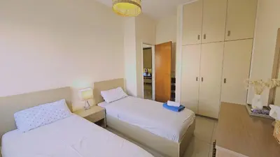 a bedroom with two beds and a mirror at STAY Amphora Apartment in Larnaka