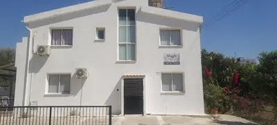 a white building with a door and a sign on it at Magic Maisonette 250m from the beach in Larnaka