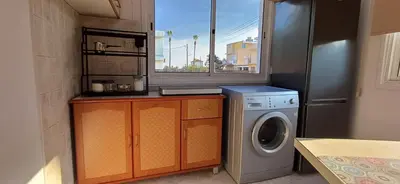 a kitchen with a washing machine and a window at Magic Maisonette 250m from the beach in Larnaka