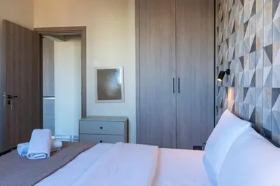 a bedroom with a large white bed and a mirror at Mosaic - 1 Bedroom Apartment in Larnaca in Larnaka