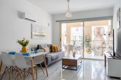 a living room with a couch and a table at Infinity - One-Bedroom Apt W Terrace in Larnaca in Larnaka